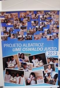 Banner com fotos de alunos da Oswaldo Justo durante execução de trabalho para o Albatroz na Escola