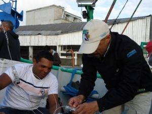 Dimas Gianuca, do Projeto Albatroz, auxiliando o pescador na utilização do hook pod